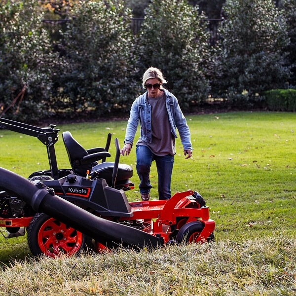 Un véhicule hors-route utilitaire (UTV) Kubota orange avec cabine fermée circulant sur un sentier forestier enneigé, illustrant sa conception robuste pour les terrains hivernaux les plus exigeants.